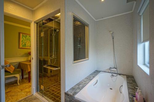 a large bathroom with a tub and a shower at At Pingnakorn Nimman Hotel in Chiang Mai