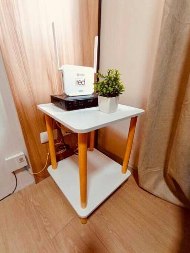 a small table with a laptop and a plant on it at Serenity in Style: Scandinavian Zen in Nuvali in Pitland