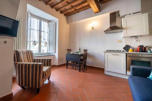 a kitchen with a table and chairs in a room at La Dimora nell'Anfiteatro Superior room and apartment Self check in Elevator Air Conditioning in Lucca