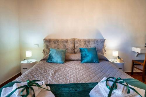 a bedroom with a large bed with blue pillows at La Dimora nell'Anfiteatro Superior room and apartment Self check in Elevator Air Conditioning in Lucca