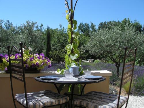 une table et deux chaises assises sur une terrasse dans l'établissement Clos des Lavandes - Luberon, à Lacoste