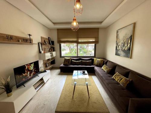 a living room with a couch and a tv at 5 Star Apartment Near Airport in Nouaseur