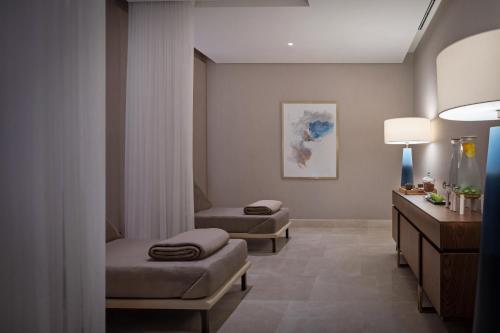 a hospital room with two beds and a table at Address Beach Resort Bahrain in Manama
