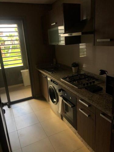 a kitchen with a stove and a washing machine at 5 Star Apartment Near Airport in Nouaseur