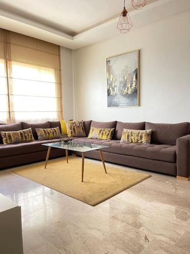 a living room with a couch and a coffee table at 5 Star Apartment Near Airport in Nouaseur