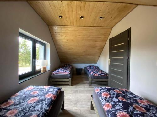 1 Schlafzimmer mit 2 Betten und Holzdecke in der Unterkunft Rodzinna Przystañ in Lubawka
