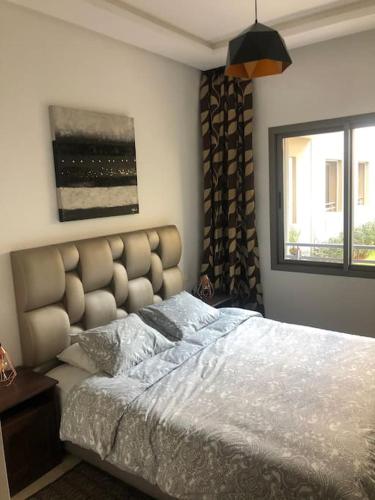 a bedroom with a large bed and a window at 5 Star Apartment Near Airport in Nouaseur