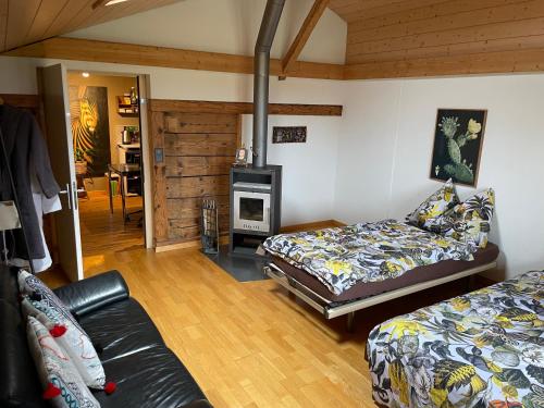 uma sala de estar com 2 camas e uma lareira em Sérénité, cherry blossom special, peaceful Spiez em Einigen