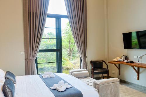 a hotel room with a bed and a large window at Phuping Valley Resort in Tak