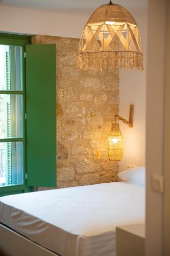 a bedroom with a bed with a green door and a lamp at Olvio Suites in Kardamili