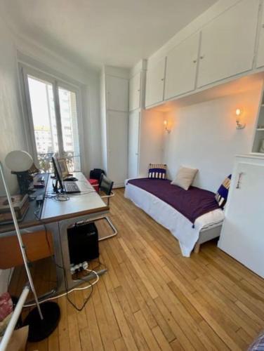 Un dormitorio con una cama y un escritorio con una computadora. en Luxurious appartement Montreuil, en Montreuil