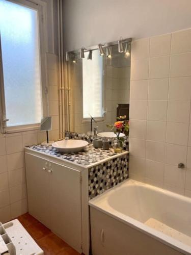 Un baño con bañera, lavabo y espejo. en Luxurious appartement Montreuil, en Montreuil