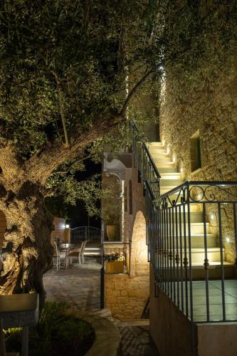 a stairway leading to a building with a tree at Olvio Suites in Kardamili
