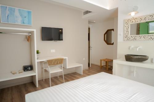 a white bedroom with a bed and a desk at Olvio Suites in Kardamili