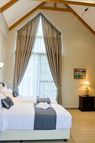 a bedroom with two beds and a large window at Phuping Valley Resort in Tak