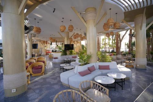 um átrio com um sofá branco, mesas e cadeiras em Hotel Novotel Sharm El-Sheikh em Sharm el Sheikh