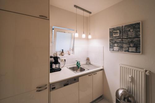 een badkamer met een wastafel en een spiegel bij Tallskog - Dein Apartment am Naturstrand Hohen Wieschendorf in Hohenkirchen