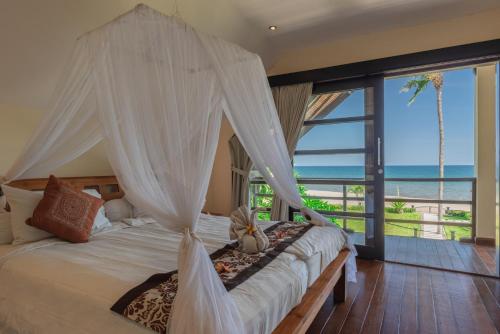 Schlafzimmer mit einem Bett und Meerblick in der Unterkunft Villa Banjar Beach in Banjar
