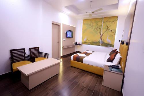 a hotel room with a bed and a tv at Hotel Krishna Sagar Ghaziabad in Ghaziabad
