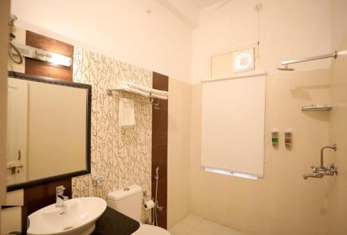 a bathroom with a white toilet and a sink at Sterling Jaisinghgarh Udaipur in Udaipur