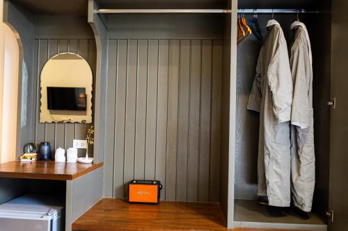 a room with a closet with a sink and a mirror at Phuping Valley Resort in Tak