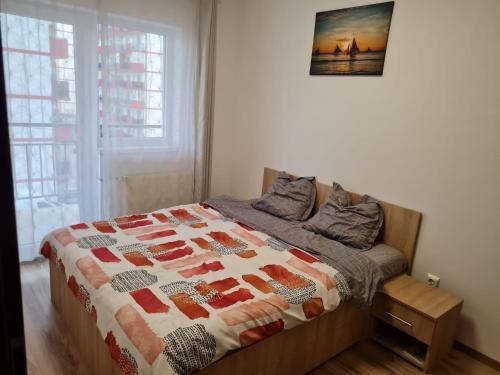 a bedroom with a bed with a quilt on it at A & I Apartment in Sibiu