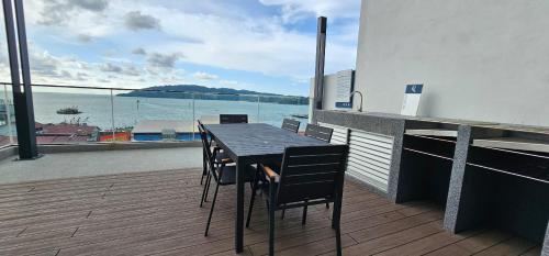 uma mesa e cadeiras numa varanda com vista para o oceano em The Shore - JJ's Unit with City View em Kota Kinabalu