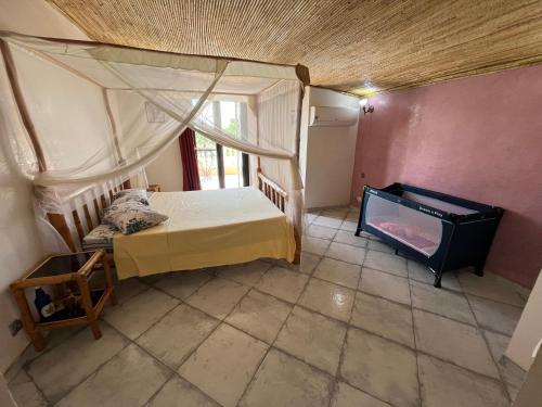 ein kleines Schlafzimmer mit einem Bett und einem Fenster in der Unterkunft Villa bonheur Somone in Somone
