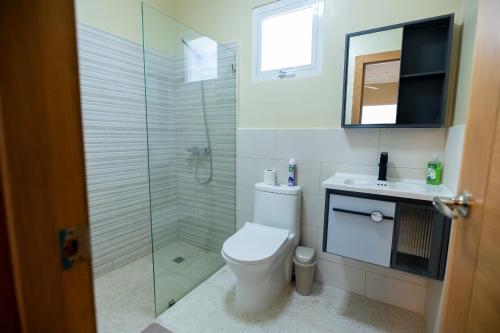 y baño con aseo y ducha acristalada. en Gadie Villa, en Punta Cana
