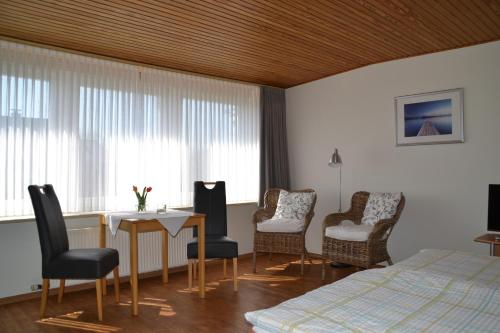 a bedroom with a bed and a table and chairs at Haus Widder Nr3 in Kopendorf