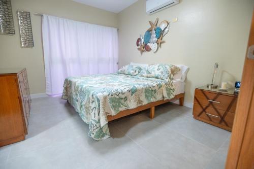 1 dormitorio con 1 cama, vestidor y ventana en Gadie Villa, en Punta Cana