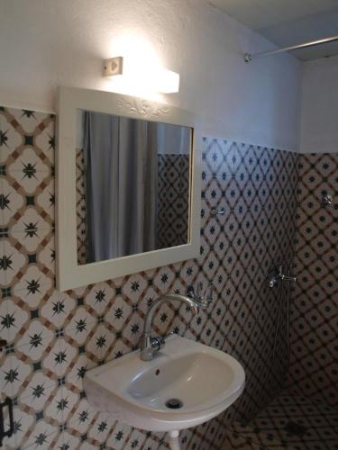 ein Bad mit einem Waschbecken und einem Spiegel in der Unterkunft Country House Spitaki Λόχος in Velika