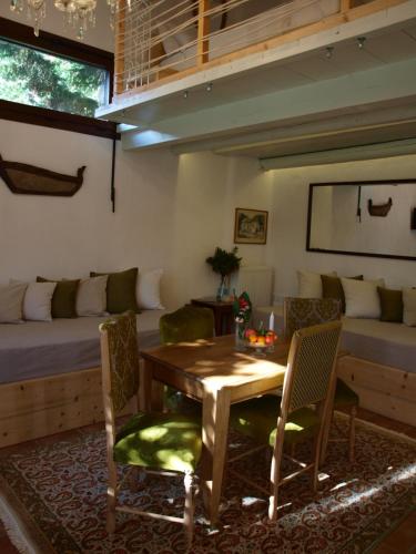 ein Wohnzimmer mit einem Tisch, Stühlen und einem Sofa in der Unterkunft Country House Spitaki Λόχος in Velika