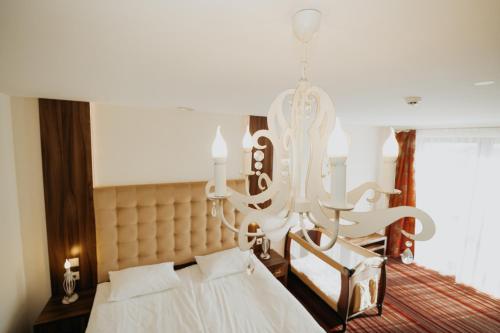 a bedroom with a bed and a chandelier at Noclegi - Apartamenty Żołynianka in Żołynia