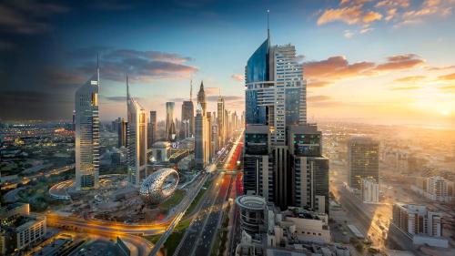 a view of a large city at sunset at voco Dubai, an IHG Hotel in Dubai