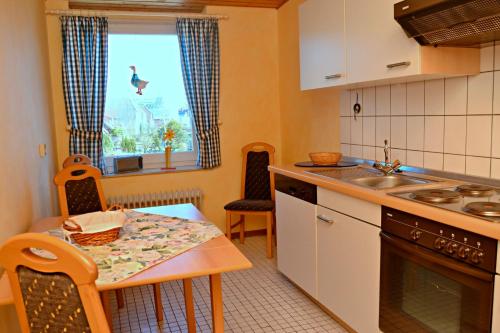 a kitchen with a table and a sink and a window at Haus Widder Nr2 in Kopendorf