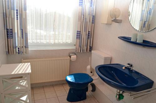 a bathroom with a blue toilet and a sink at Haus Widder Nr2 in Kopendorf