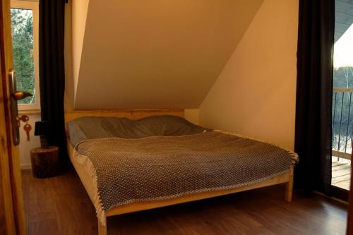 a small bed in a room with a window at Watrosówka in Pasym