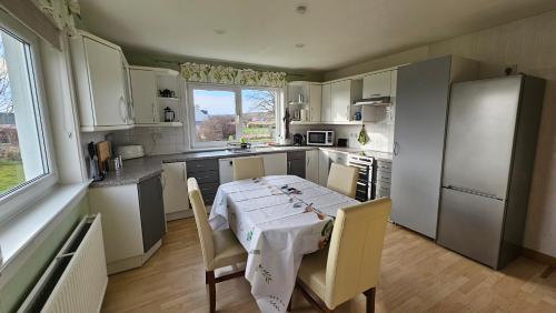 una cocina con mesa y mantel blanco. en Donmar Cottage, en Skeabost