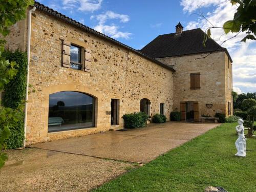 - un bâtiment en briques avec une statue en face dans l'établissement Le colombier/Piscine/Domme, à Domme