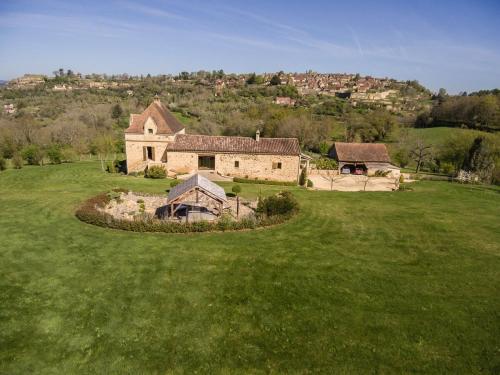 une ancienne maison en pierre dans un champ d'herbe dans l'établissement Le colombier/Piscine/Domme, à Domme