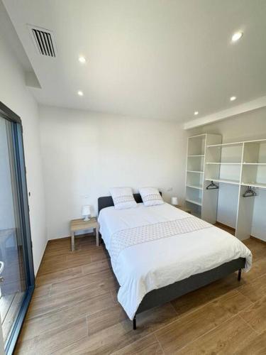 une chambre avec un grand lit dans une pièce dans l'établissement Appartement neuf bas de villa 1, à Furiani
