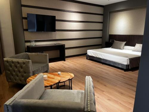 a hotel room with a bed and a table and chairs at Hotel Reyes Ziries in Albolote