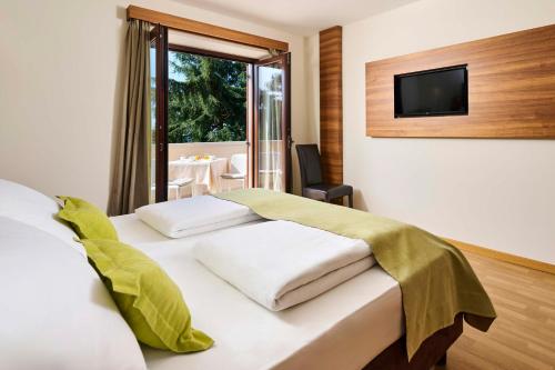 um quarto com uma cama e uma televisão na parede em Villa Dobravac Wine Estate em Rovinj