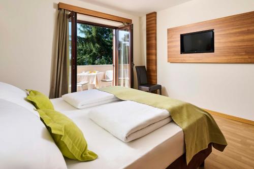 a bedroom with a bed with a television on a wall at Villa Dobravac Wine Estate in Rovinj