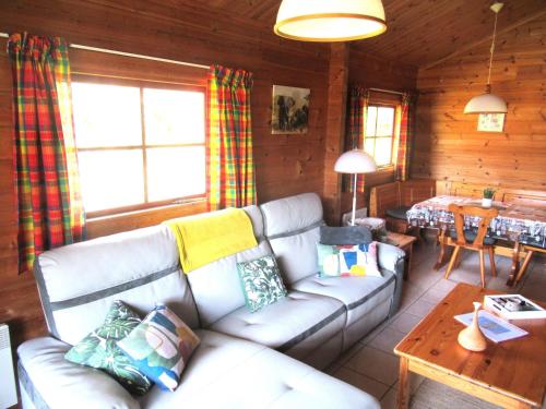 un salon avec un canapé et une table dans l'établissement Le chalet Magalli, à Mauroux