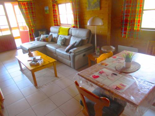 un soggiorno con divano e tavolo di Le chalet Magalli a Mauroux