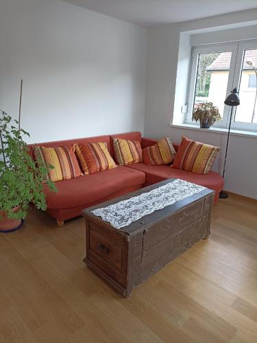 比奇的住宿－Bitche, au pied de la Citadelle，客厅配有红色的沙发和桌子