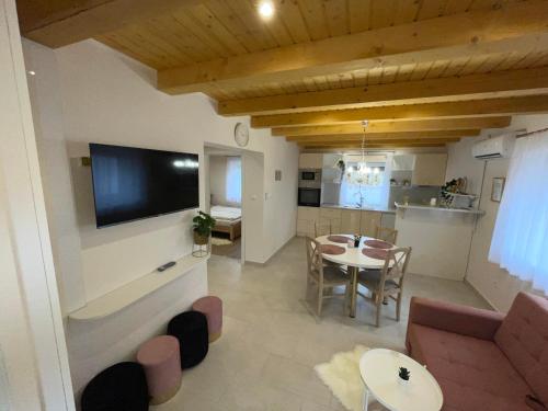 Una sala de estar con un sofá y un comedor. en Vízitündér Pihenőpark Apartmanok, en Újhartyán