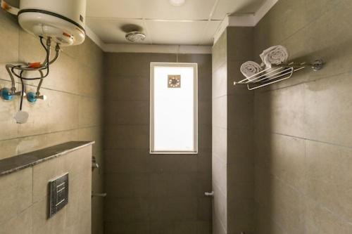 a bathroom with a window and a door with at TIPSYY INN 007 in Gurgaon